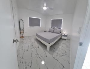 拉罗汤加Te Aro Villa in Muri 1 &2的一间铺有大理石地板的卧室,配有一张床。 更多17张照片