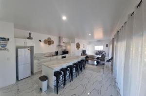 拉罗汤加Te Aro Villa in Muri 1 &2的一个带酒吧凳的大岛的厨房