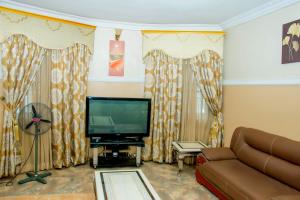 a living room with a couch and a flat screen tv at Exclusive Villa 24Hr Solar Electricity in Umuahia