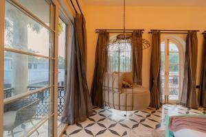 a room with a chair on a balcony at ELIVAAS 4 BHK Villa with Pvt Pool & Jacuzzi-Yashgeet in Siolim +108 photos