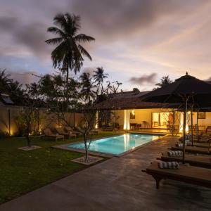 un resort con piscina di notte di Mudliyar House a Hikkaduwa