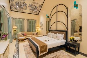 a bedroom with a bed and a living room at ELIVAAS 4 BHK Villa with Pvt Pool & Jacuzzi-Yashgeet in Siolim