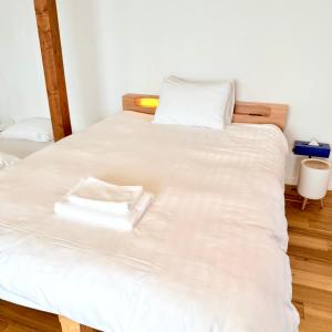 two beds in a room with white sheets at Seaside Inn KOKOMO in Hakodate +37 photos