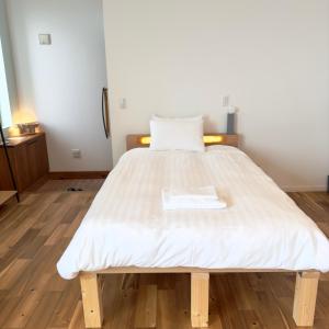 a large bed with a white bedspread on it at Seaside Inn KOKOMO in Hakodate