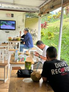 PalasariTenda Kebun Sukaharja Bogor的一群人坐在餐车里的桌子旁。