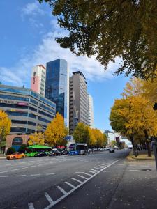 a city street with cars and buildings in the background at Let's Stay in Seoul