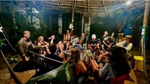 a group of people sitting around a table in a room at The Seaside Bungalow Hostel and Bar in Hoi An