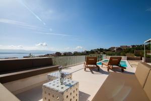 a patio with a couch and chairs on a balcony at Modern Mediterranean Oasis - Villa ''BOLKA'' in Bol