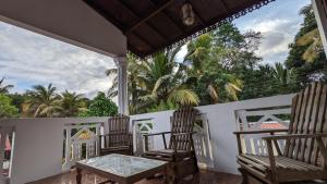 a porch with two chairs and a table at Hirikatiya Edge in Dickwella