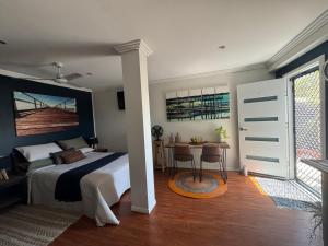 a bedroom with a bed and a table and a desk at Tranquility by the Bay in Hervey Bay