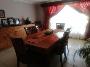 a dining room with a wooden table and chairs at Mbele's home stay in Bloemfontein