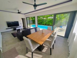 comedor con mesa de madera y sala de estar en Modern pool villa 3 bedrooms, en Rawai Beach