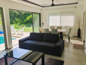 Una sala de estar con un sofá negro y una mesa. en Modern pool villa 3 bedrooms, en Rawai Beach