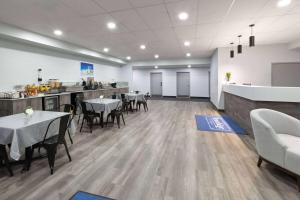 a restaurant with tables and chairs and a kitchen at Travelodge by Wyndham Cochrane Ontario in Cochrane