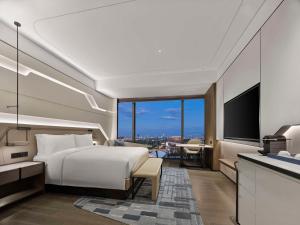 a hotel room with a bed and a television at Hilton Shanghai Hongqiao International Airport in Shanghai