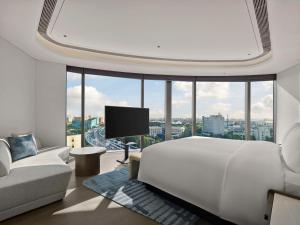 a bedroom with a large white bed and a large window at Hilton Shanghai Hongqiao International Airport in Shanghai