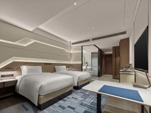 a hotel room with two beds and a table at Hilton Shanghai Hongqiao International Airport in Shanghai