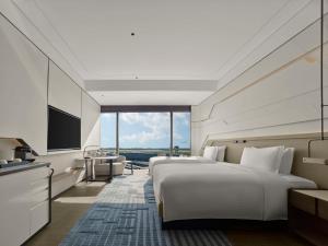 a hotel room with two beds and a television at Hilton Shanghai Hongqiao International Airport in Shanghai