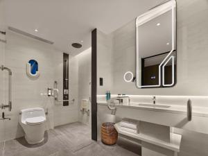 a bathroom with a toilet and a sink and a tub at Hilton Shanghai Hongqiao International Airport in Shanghai
