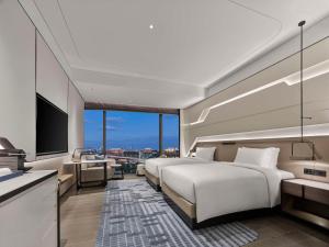 a hotel room with two beds and a television at Hilton Shanghai Hongqiao International Airport in Shanghai