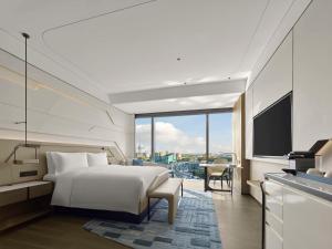 a hotel room with a bed and a television at Hilton Shanghai Hongqiao International Airport in Shanghai