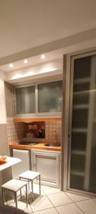 a kitchen with white cabinets and a table and chairs at Tisara home in Portici +10 photos
