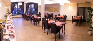 una sala da pranzo con tavoli e sedie in un ristorante di Anthimos a Baile Felix