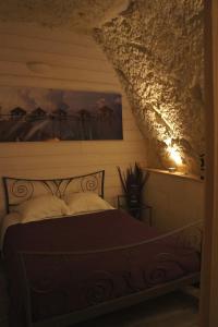 Un dormitorio con una cama y un cuadro en la pared. en Chambres d'Hôtes Troglodytes Le Clos de L'Hermitage, en Amboise 3 fotos más