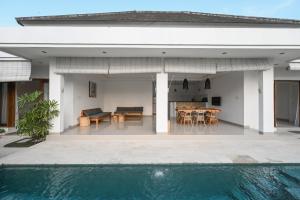 a house with a swimming pool next to a house at Maganda Villa in Tabanan +13 photos