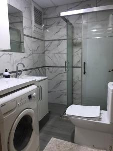 a bathroom with a toilet and a washing machine at meva pansiyon in Küçük Çığlı