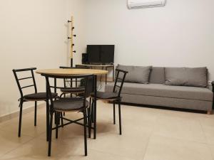 een woonkamer met een tafel, stoelen en een bank bij GardenHouse in Athene