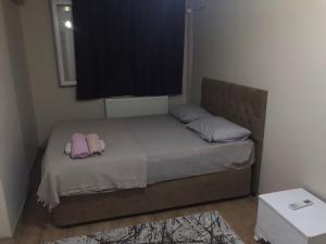 a small bedroom with a bed with two pink pillows at meva pansiyon in Küçük Çığlı +5 photos