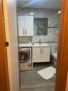 a bathroom with a sink and a washing machine at meva pansiyon in Küçük Çığlı