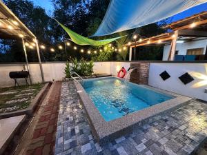 ein Schwimmbad im Hinterhof eines Hauses nachts in der Unterkunft DeCherating privatepool in Cherating