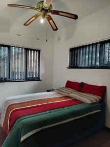 Un dormitorio con una cama con ventilador de techo. en Montclair Forest Guest House, en Durban 54 fotos más