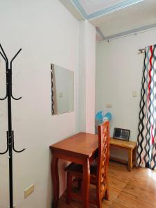 a room with a wooden table and a desk with a laptop at Bogah Lodge in Banaue