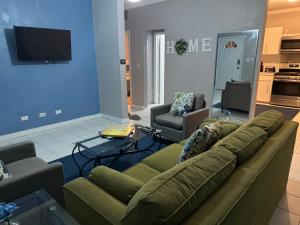 a living room with a couch and a tv at Kozy Bahamas Getaway in Nassau