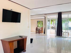 a living room with a flat screen tv on a wall at Chill Lay Beach House in Ko Lanta Yai