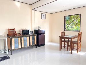 a kitchen with a table and a refrigerator and a table and chairs at Chill Lay Beach House in Ko Lanta Yai