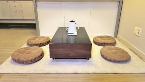 a living room with a table and three circular stools at st ar house in Goyang