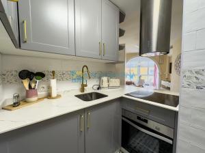 a kitchen with white cabinets and a sink at Estudio Zurycris in Torrox Costa
