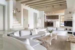 a living room with white furniture and a table at Villa Assa -Mykonos in Mýkonos City