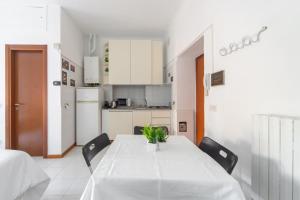a kitchen with a white table with chairs and a white counter top at Locami Apartment Niguarda in Milan