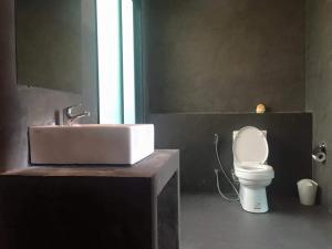 ein Badezimmer mit einem weißen Waschbecken und einer Toilette in der Unterkunft boomresort in Ron Phibun + 5 Fotos