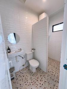 a white bathroom with a toilet and a sink at Casa de Gaudete 3 Bedroom King Size Villa Lembang in Genteng +12 photos