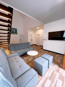 a living room with two couches and a tv at Casa de Gaudete 3 Bedroom King Size Villa Lembang in Genteng