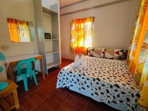 a bedroom with a bed and a desk and windows at Bogah Lodge in Banaue +126 photos