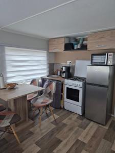 a kitchen with a table and a stove top oven at Mobil-Home N 48 in Fourmies