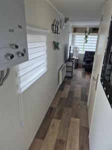 a hallway of a house with white walls and wood floors at Mobil-Home N 48 in Fourmies