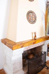 a living room with a fireplace with a wooden mantle at Señorío de Ves in Casas de Ves